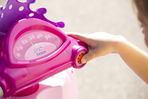 Kind speelt met roze scooter