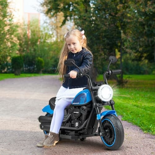 Meisje op een blauwe kinderfiets in het park