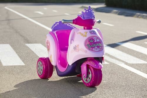 Roze kinderscooter met prinsessenmotief op een weg