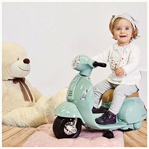 Kleuter op een speelgoed scooter met grote teddybeer